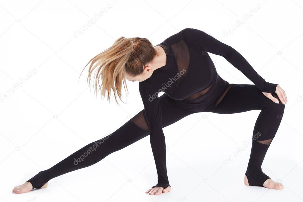 Beautiful young sexy blond woman perfect athlete slim figure in gymnastics exercise stretching, trainer, fitness health wear sports in gym dressed in comfortable casual clothes relaxes and meditation.