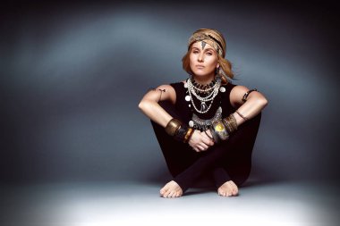 Güzel seksi genç kadın sarışın saç giymek siyah sıska spor giyim takım elbise aksesuar takı bilezik kolye şapka Hint tarzı yoga poz denge meditasyon sakin ol mutlu asana lotus sağlık yaşam dua.