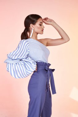 Seksi güzel kadın oldukça parlak makyaj kozmetik yüz bakım uzun saçlı esmer aşınma mavi pantolon bluz giyim office kıyafet tarihi parti bahar koleksiyonu aksesuar takı Satılık Dergisi çantası yüz.