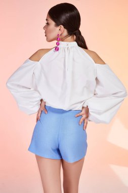 Güzel genç seksi esmer kadın portre arka plan, akşam parti, ayrık uzun gür, dolgun dudaklar, kozmetik, vücut bakımı, makyaj boyun yumuşak deri, bronz ten rengi aksesuar takı küpe omuzlar.