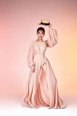 Esmer güzel kadın yüz seksi sıska vücut şekli tan cilt bakım giyim moda uzun elbise ipek bej pist modeli studio giyim tarzı yaz tatil yürüyüş tarihi beach parti makyaj aksesuar şapka.