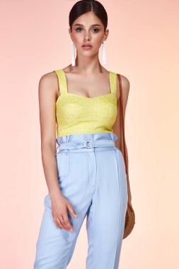 Güzel genç seksi kız uzun esmer saç stili ile parlak bir akşam ile mükemmel yaz tan ince gövde sarı ipek bluz mavi pantolon Ayakkabı mükemmel vücut şekli aksesuar çantası içinde giyinmiş makyaj.