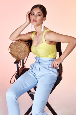 Güzel genç seksi kız uzun esmer saç stili ile parlak bir akşam ile mükemmel yaz tan ince gövde sarı ipek bluz mavi pantolon Ayakkabı mükemmel vücut şekli aksesuar çantası içinde giyinmiş makyaj.