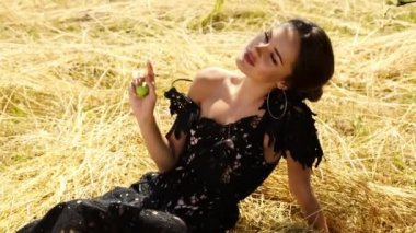 Genç güzel kadın uzun saçları parlak makyaj doğa arka plan manzara kuru spike çim ve sıcak hava yaz modeli siyah dantel elbise aksesuar romantik tarih güneş Parlatıcı tan içinde giyinmiş.