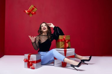 Güzel genç güzel kadın parlak akşam makyaj parlak kırmızı ruj dudakları esmer kıvırcık saçlı şenlikli duygudurum Kış Yılbaşı yeni yıl St. Valentine's gün ve Doğum günü hediye sürprizi ile.