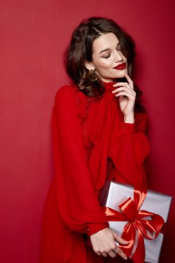 Güzel, genç, seksi, zayıf, zayıf bir kadın akşam makyajı şık, şık elbise koleksiyonu, esmer, hediye kutuları kırmızı ipek papyonlar, bayram partisi, Noel Sevgililer Günü..