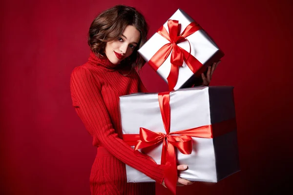 Beautiful sexy young brunette girl with wavy hair bright evening make-up red lips long fluffy eyelashes hold gift box holiday New Year  joy fun happy merry Christmas Eve party celebration.