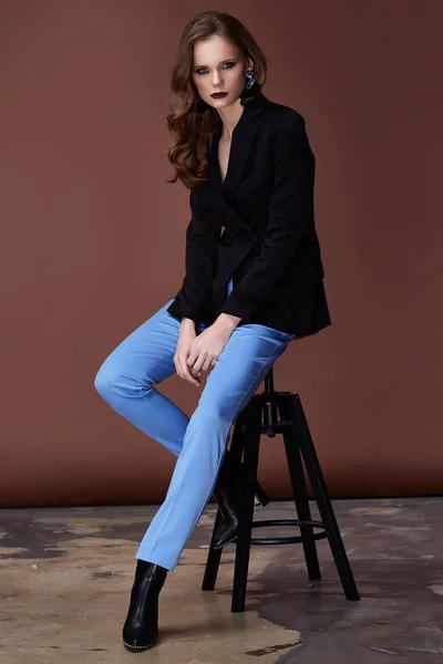 美しいセクシーな若いビジネス女性黒髪夜化粧青フォーマルなスーツのジャケットを着てパンツ会議散歩コレクション完璧なボディ形の椅子のハイヒールの靴ビジネス服 — ストック写真