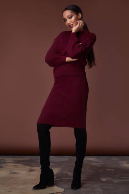 Esmer güzel kadın seksi sıska vücut şekli tan cilt bakım giyim moda elbise koyu kırmızı renk pist modeli katalog giyim stil stüdyo bahar yürüyüş tarihi makyaj takı için yüz.