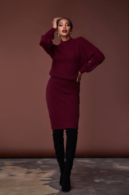 Esmer güzel kadın seksi sıska vücut şekli tan cilt bakım giyim moda elbise koyu kırmızı renk pist modeli katalog giyim stil stüdyo bahar yürüyüş tarihi makyaj takı için yüz.