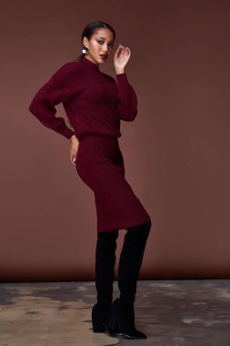 Esmer güzel kadın seksi sıska vücut şekli tan cilt bakım giyim moda elbise koyu kırmızı renk pist modeli katalog giyim stil stüdyo bahar yürüyüş tarihi makyaj takı için yüz.