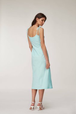 Güzel bir kadın yüzü esmer, esmer, ten renginde, moda yaz koleksiyonu organik pamuk, açık mavi, ince elbise tarzı romantik randevu yürüyüşü, aksesuar ayakkabılar..