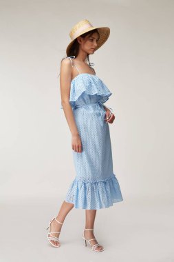 Güzel bir kadın yüzü esmer, esmer, ten renginde, moda yaz koleksiyonu, organik pamuk dantel, uzun mavi elbise tarzı romantik randevu yürüyüşü, aksesuar ve ayakkabı sandaletleri giyer..