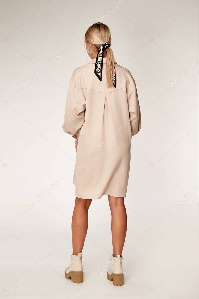 Beautiful sexy elegance woman skin tan body fashion model glamour pose wear trend casual clothes party summer beige long shirt dress collection makeup hair style blond success accessory studio.