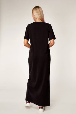 Uzun saçlı, sarışın, sıska, vücut makyajlı, siyah elbise koleksiyonu katalog tarzı moda aksesuarları satan, uzun boylu, seksi bir kadın..