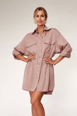 Güzel ve seksi bir kadın ten rengi ten rengi ten rengi ten rengi ten rengi manken pozu gündelik kıyafetler yaz partisi pembe uzun gömlek elbise makyaj saç stili, sarışın başarı aksesuar stüdyosu..