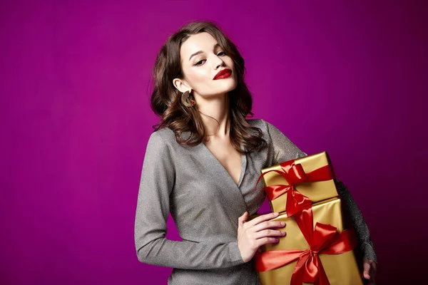 Beautiful sexy young brunette woman hair bright evening make-up red lips long fluffy eyelashes hold gift box holiday New Year  joy fun happy merry Christmas Eve party celebration St. Valentine\'s Day.