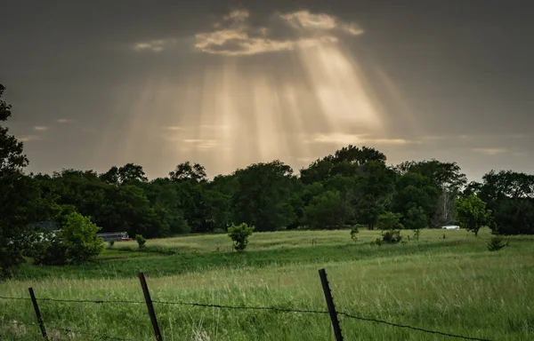 光線は 牧草地の上嵐雲の切れ間からバーストします — ストック写真