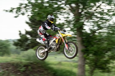 Montevideo, Amerika Birleşik Devletleri: 13 Haziran 2018: Dirt Bike Rider atlar ile bulanıklık arkasında