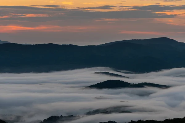 粉红色的早晨光在天空与山岛通过云在大雾山 — 图库照片