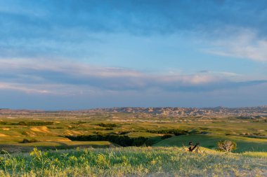 Güneşli gökyüzü Badlands ve kaymak olan otsu alanlar üzerinde