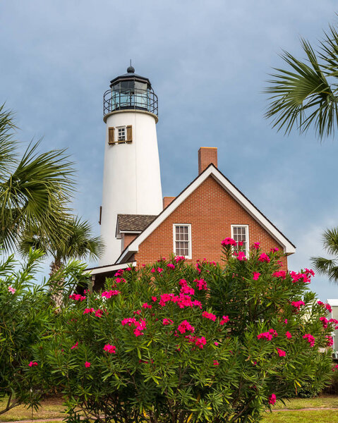 Lighthouse on St George Island with bush covered in pink flowers
