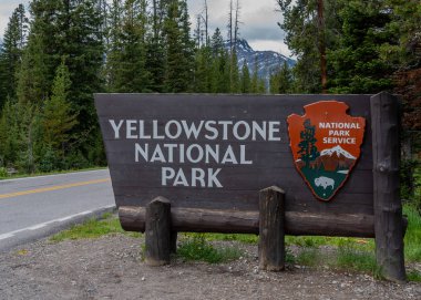 17 Haziran 2018: Yellowstone, Amerika Birleşik Devletleri: Yellowstone Milli Parkı girişi işareti dağlar mesafe ile
