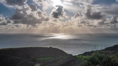 Zaman atlamalı yeşil yamaç üzerinde büyük Sur günbatımı