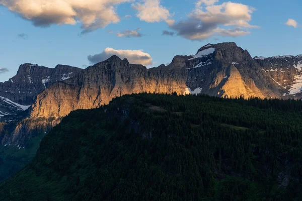 A luz da noite queima na parede da montanha — Fotografia de Stock