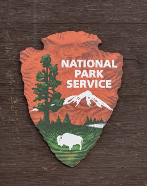 Ahşap arka planda Milli Park Hizmet Logosu