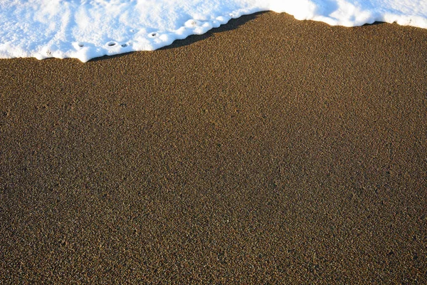 Jasna plaża z białym Surf — Zdjęcie stockowe