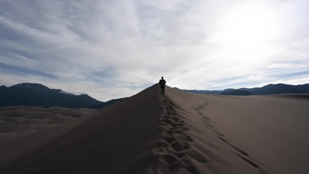 Woman Hiking Dunes Passes Camera — Stock Video