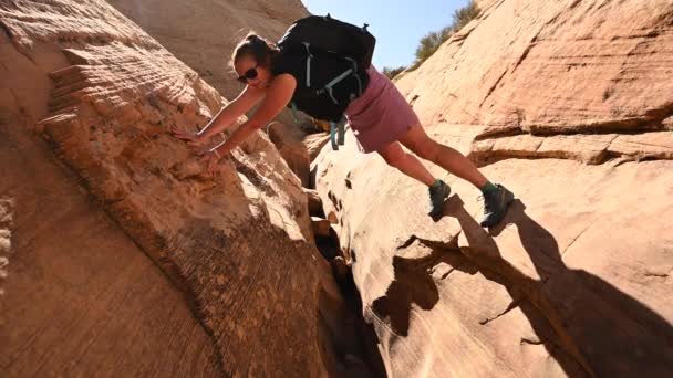 Woman Spans Two Rock Walls While Climbing Crevasse — Stock video