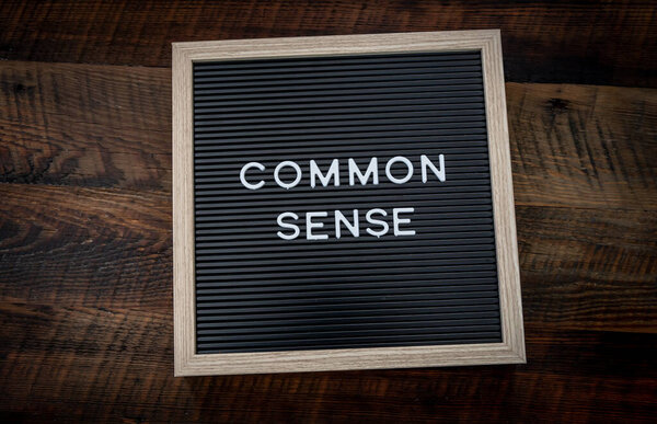 Common Sense Sign on wooden background