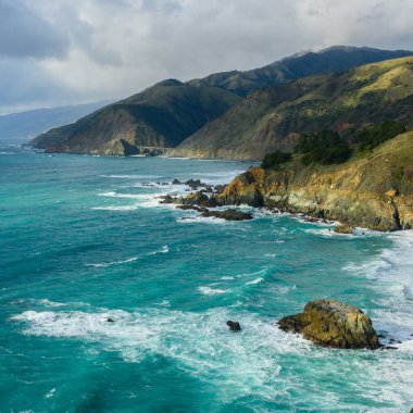 Kaliforniya 'nın ortasındaki Big Sur Sahili üzerinde Güneş Bulutları Kırıyor