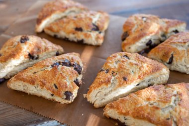 Kahverengi kağıtta ve masada çikolatalı çörekler.