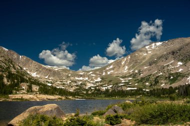 Kayalık Dağ Ulusal Parkı 'ndaki Çim Gölü' nün üzerindeki tepeyi kar banyosu kaplıyor