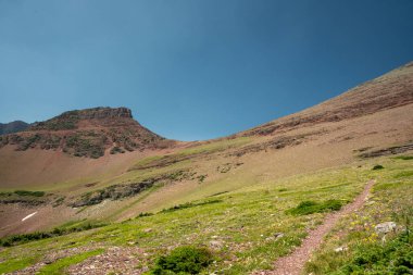 Buzul Ulusal Parkı 'ndaki açık mavi gökyüzünün altındaki Kızıl Geçide giden Yol