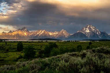 Sabah güneşi Teton Sıradağlarını ısıtmaya başlar ve fırtınadan sonra kara bulutları uzaklaştırır.