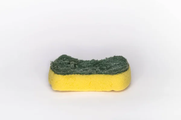 Bulaşık yıkamak için eski süngerler ve kullanım belirtileri. Süngerin iki katmanı var. Üst katman yeşil, alt katman ise sarı ve beyaz arkaplan içerir.
