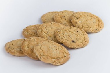 Yakın çekim mısır gevreği kurabiyeleri birden fazla parçaya ayrılır ve üç sıra vardır ve kurabiyeler kahverengidir ve resmin nesnenin yanında boş bir alan vardır ve beyaz bir arka planı vardır..