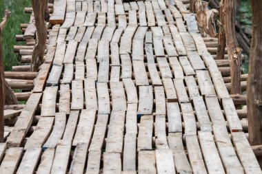 Küçük tahta parçalarından oluşan tahta bir köprü. Güçlü ve kullanışlı olmak için bir sürü bağlantı var.