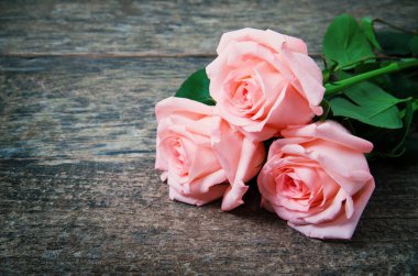 Ahşap masanın üzerinde pembe güller