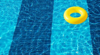 Sarı havuz yüzer, halka yüzer ferahlatıcı mavi bir yüzme havuzunda