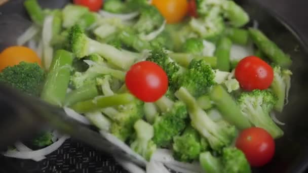 Лук, брокколи и бобы жарят на сковороде, овощи готовят. — стоковое видео