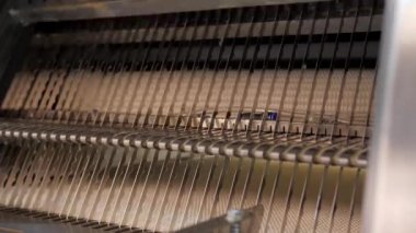 Fabrikada ekmek dilimleyici. Fabrika ekmeği kesmek için keskin bıçaklar.