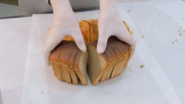 Üretimde dilimlenmiş ekmek gösteren adam.