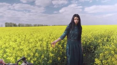 Doğada bir klip çekmek. Kız çiçek tarlasında sorunsuzca dans ediyor. Çerçevede, kamera da Steadicam tarafından görülebilir..