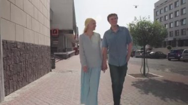 Şehir caddesinde yürüyen genç bir çift..