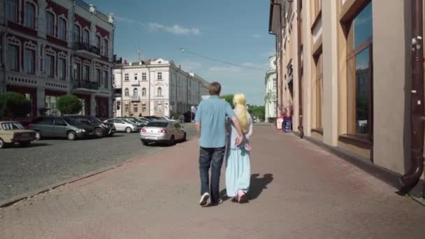 Un hombre y una mujer abrazándose pasean por la ciudad . — Vídeos de Stock